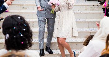 Comment choisir le lieu de son mariage ? mariés sur un escalier avec invités qui lancent des confettis